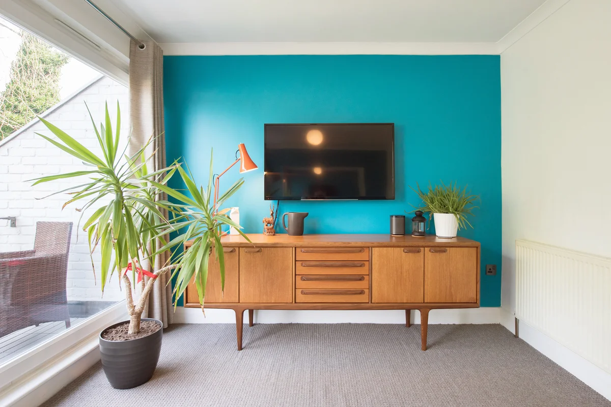 Living room decorated in a 1970s style with flat screen tv