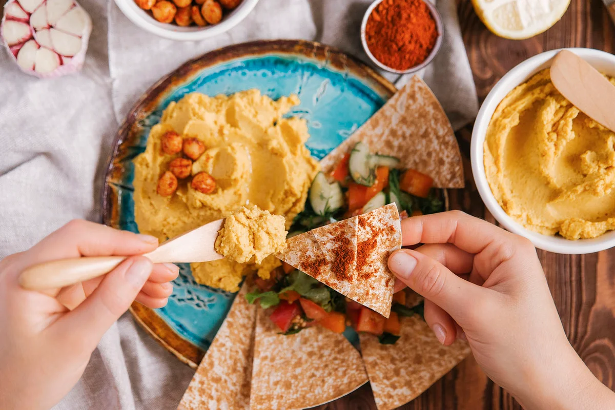 Cropped hands of woman eating food served on table