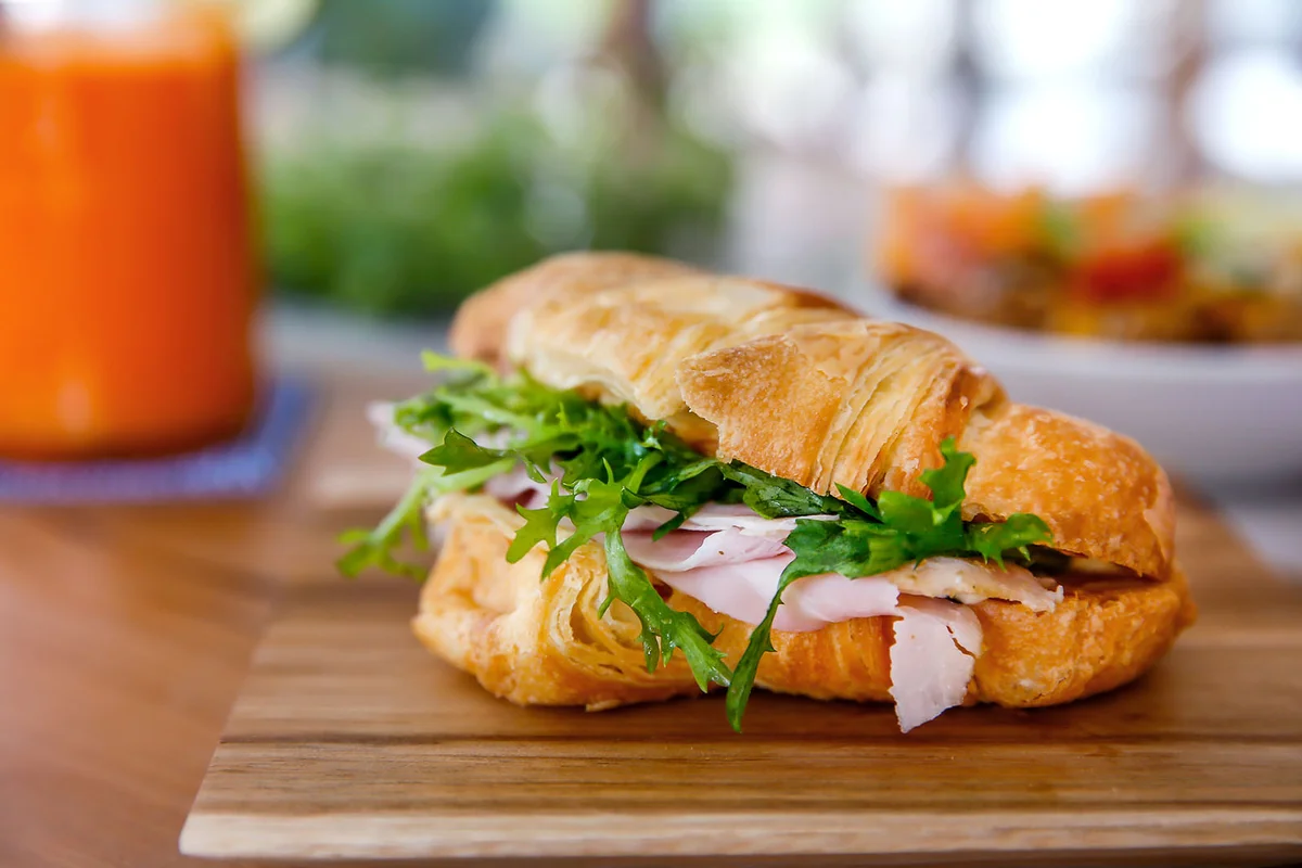 Croissant sandwich with ham and arugula
