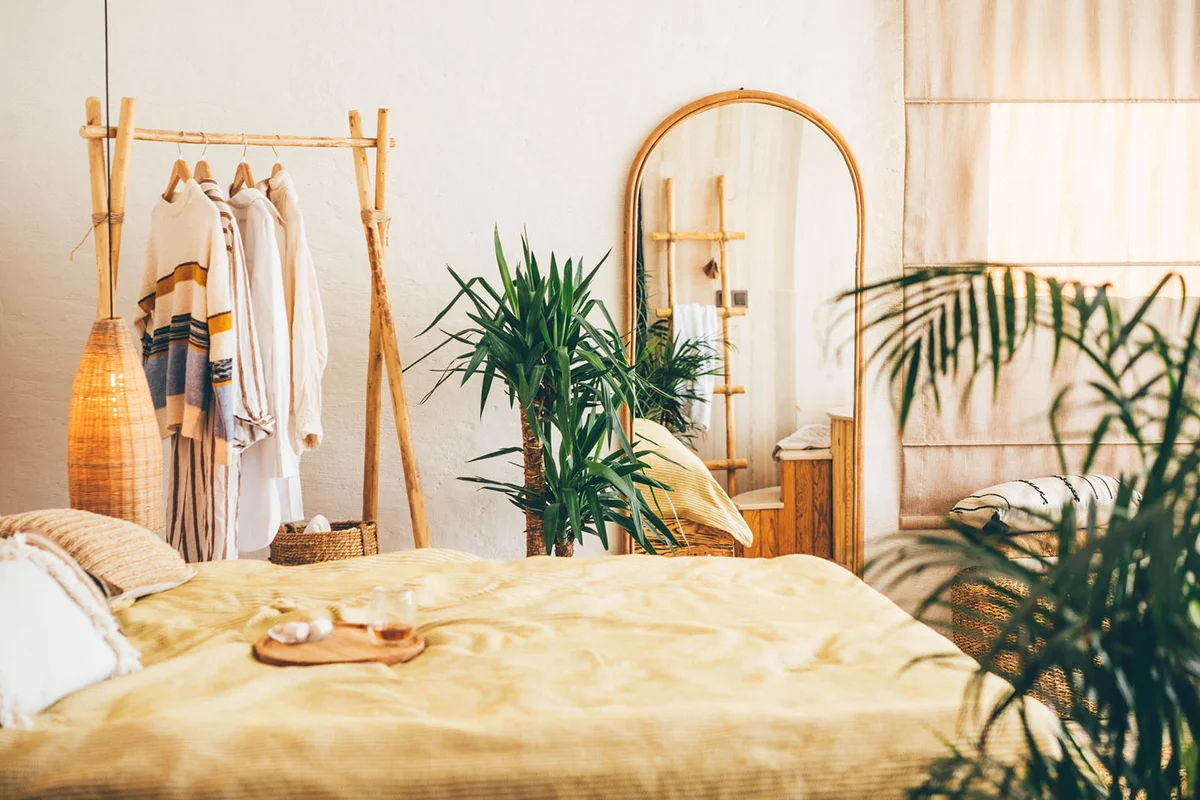 Clothes hanging on a hangers near a mirror at home