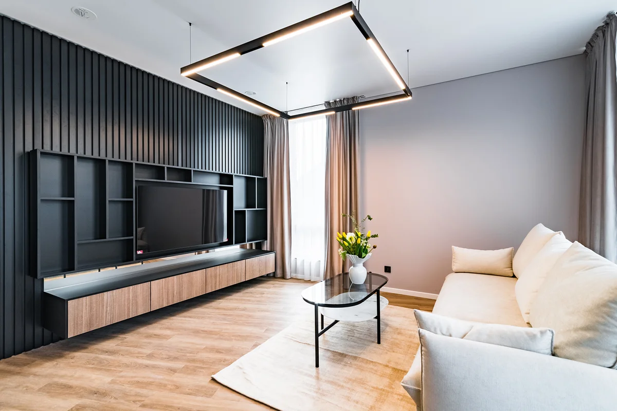 Large black shelf for large TV in a living room of an apartment.