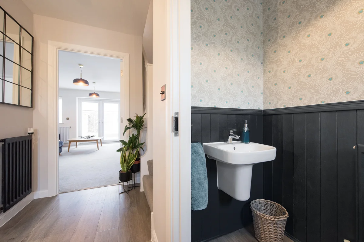 An interior view of a small downstairs toilet, with wood cladding and panelling