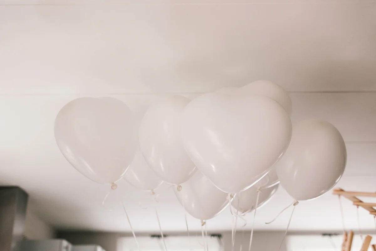 White helium balloons against ceiling