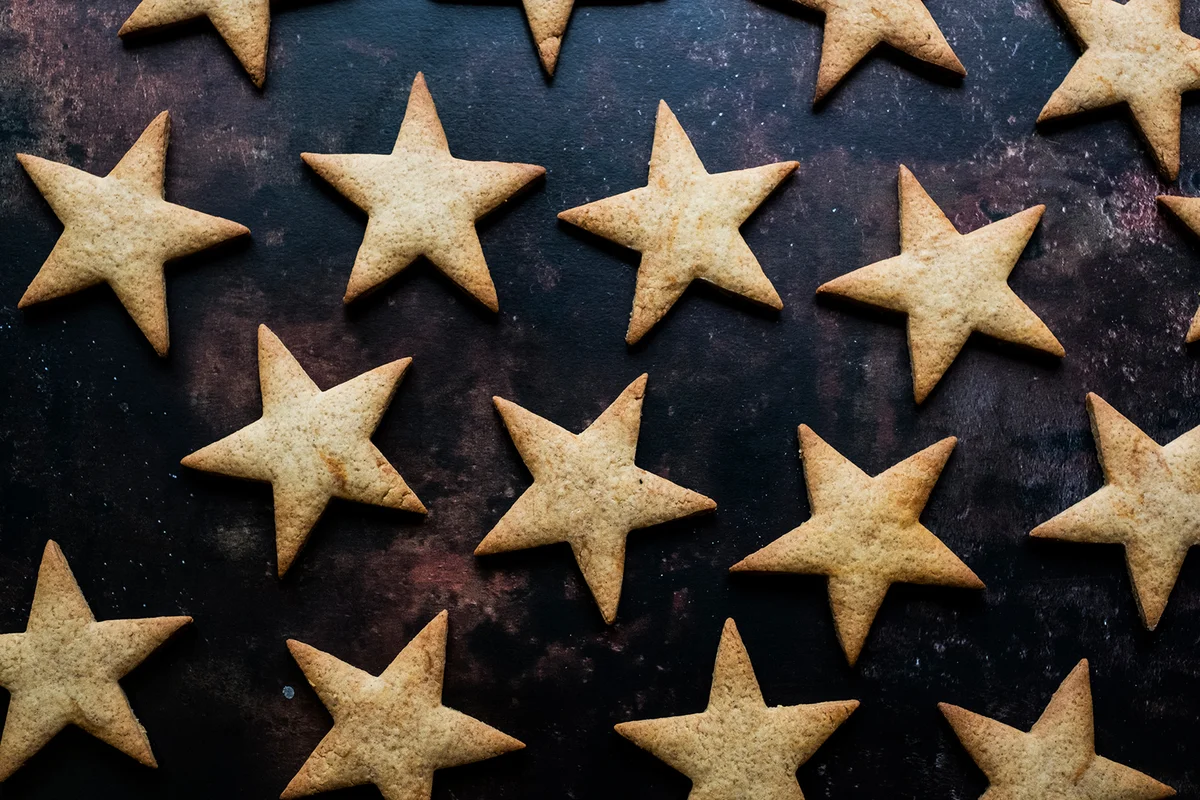 freshly baked star-shaped cookies on black background.
