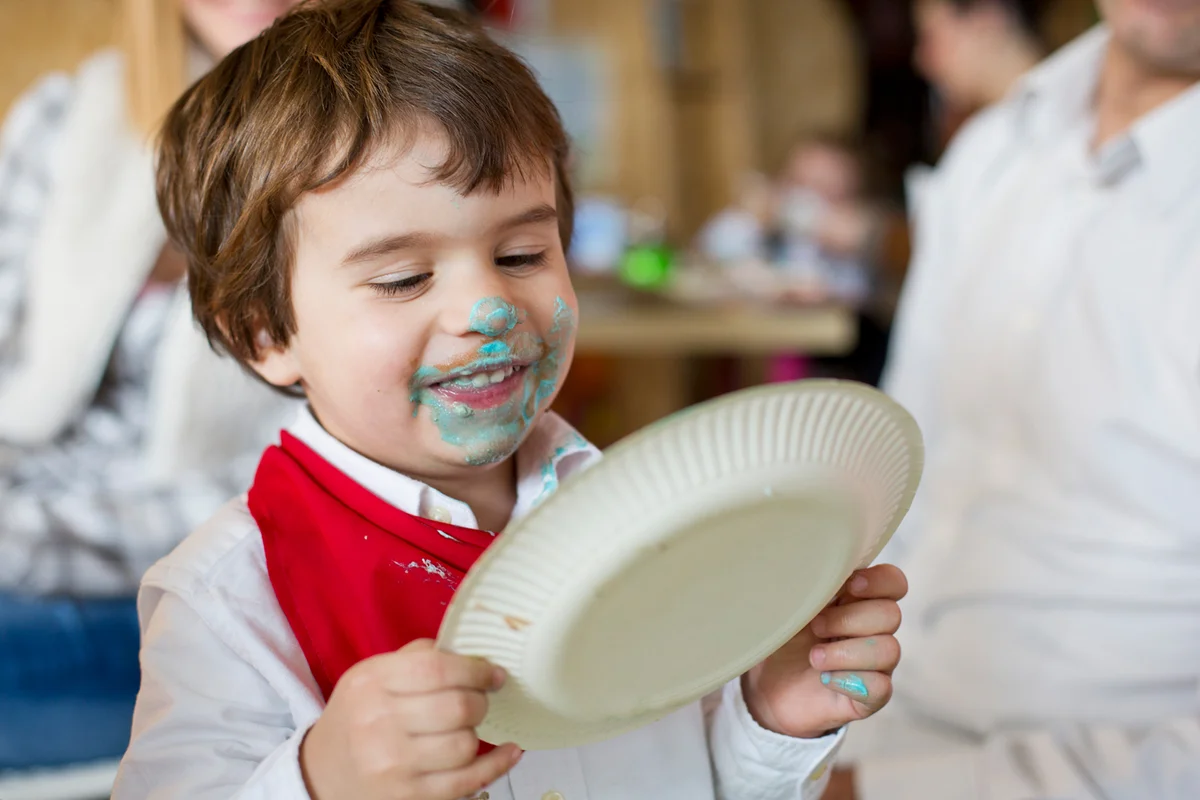 Small boy eating a birthday cake -