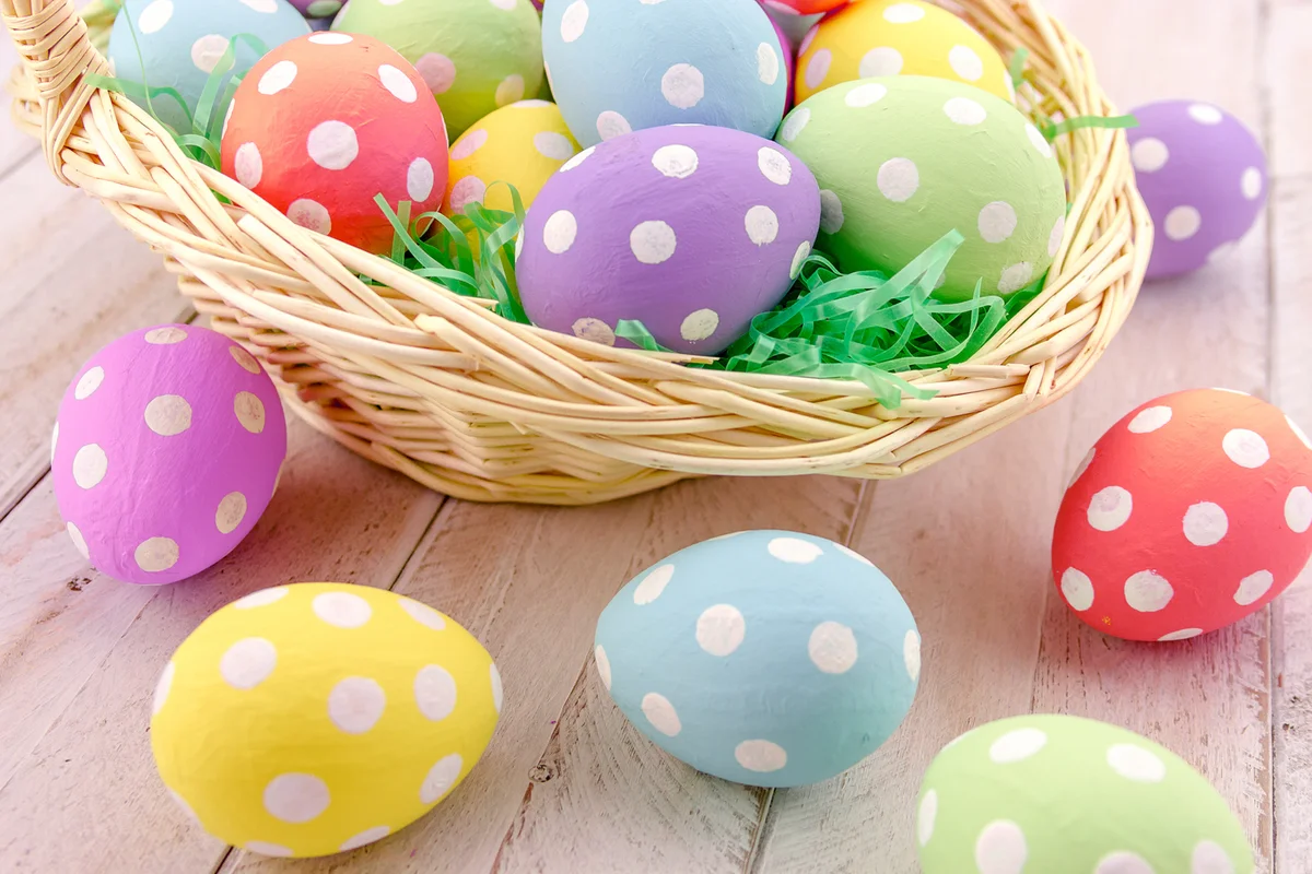 Easter basket with green grass filled with brightly colored polka dot Easter eggs