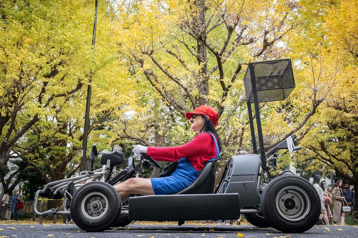 A woman drives a go-kart while dressed in Super Mario costume  - Getty Editorial