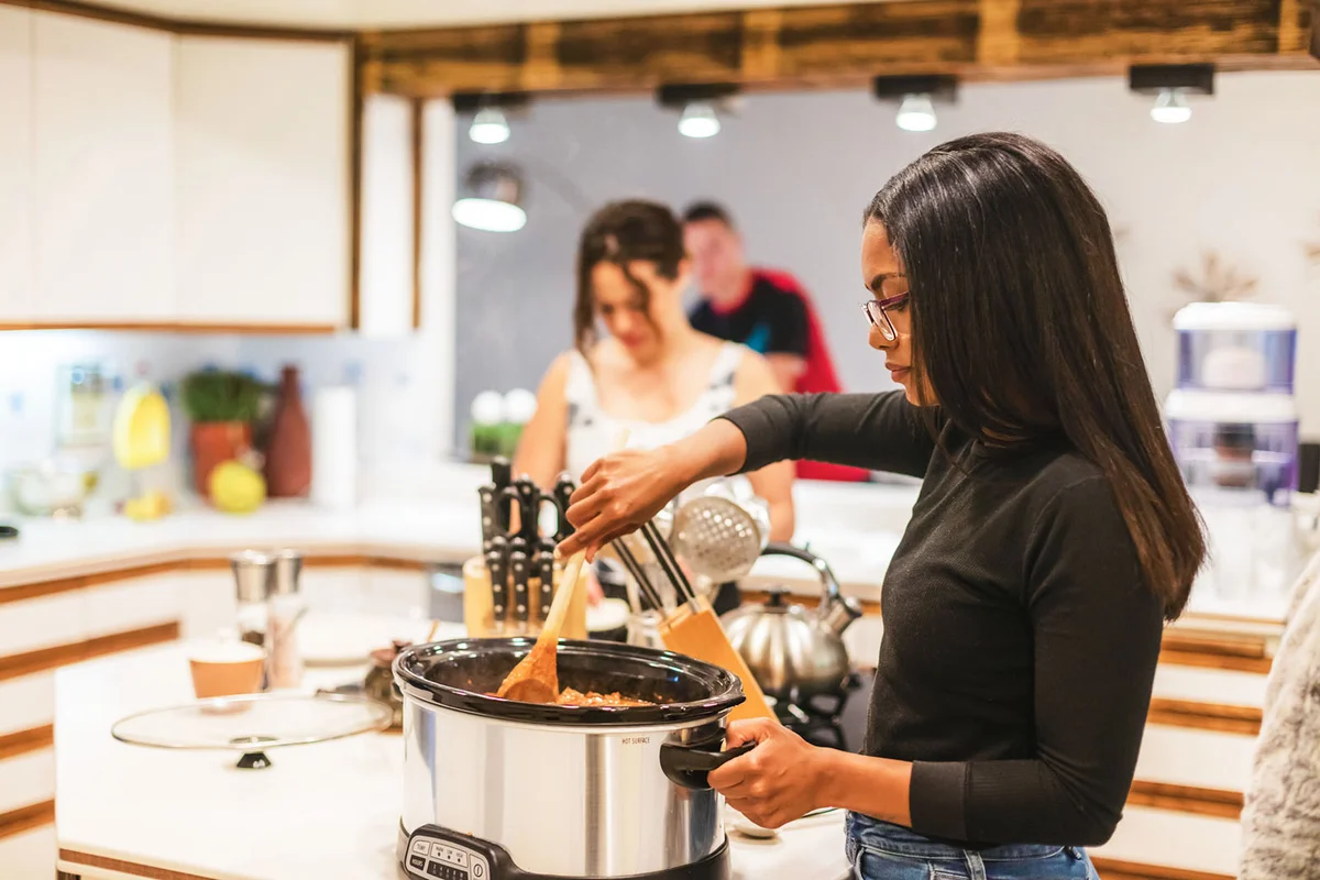 Woman using a crockpot for cooking chili