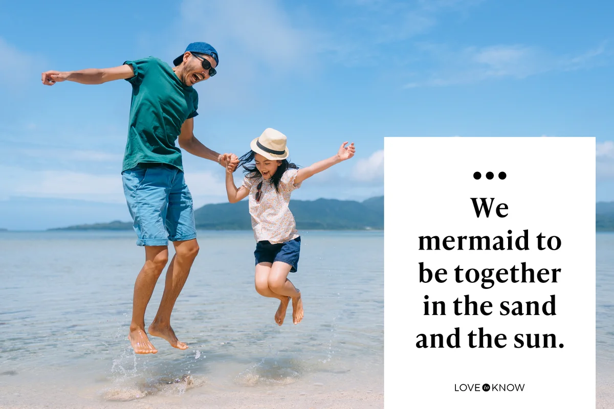 Father and young daughter jumping on beach