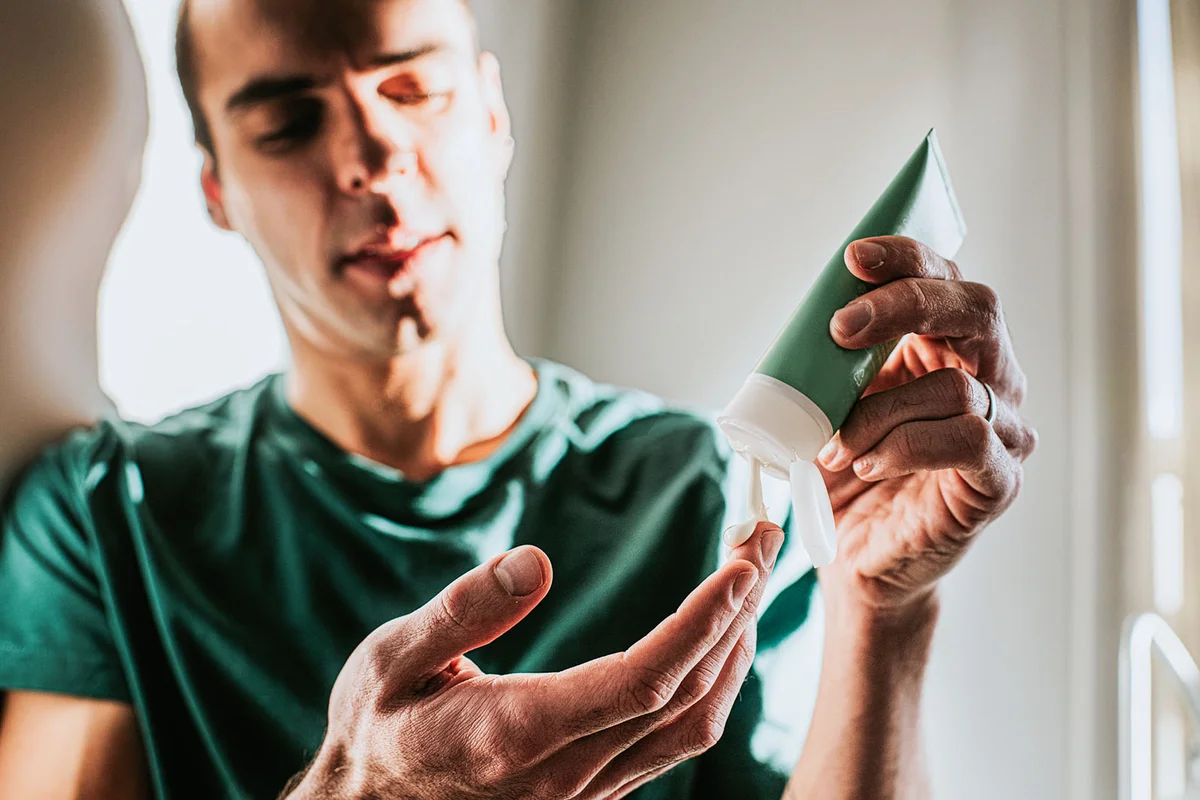 A man applies lotion to his hand