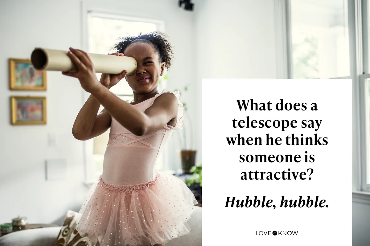 Young girl looking through homemade telescope at home