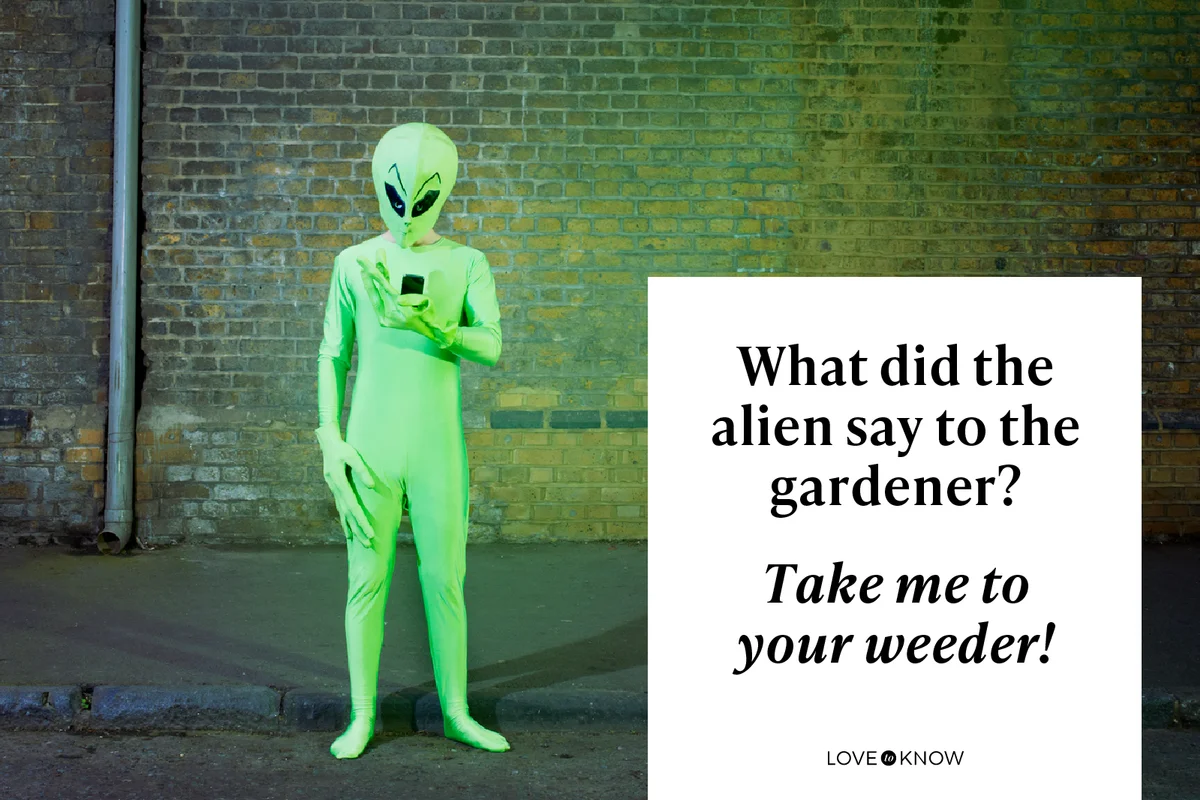 Man dressed in alien costume looking at mobile