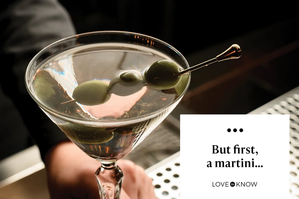 Bartender serving a martini decorated with olives