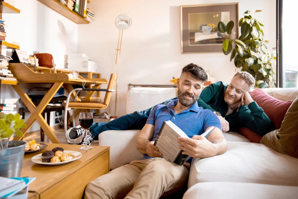 Male couple reading a book together