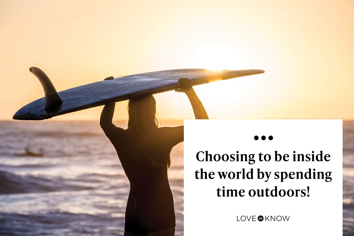 Surfer at sunrise standing on beach