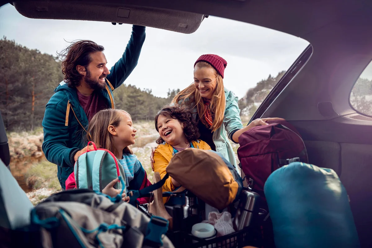 Young family getting the camping supplies out of the car