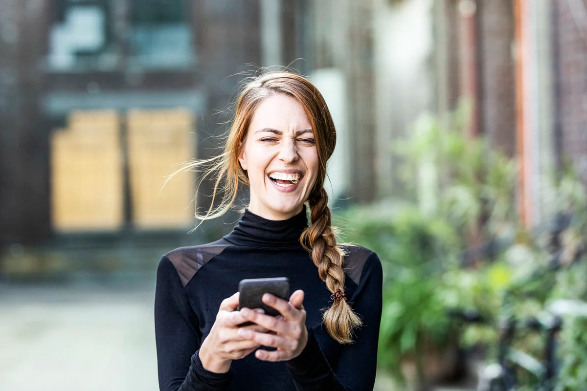 Portrait of laughing woman with smartphone