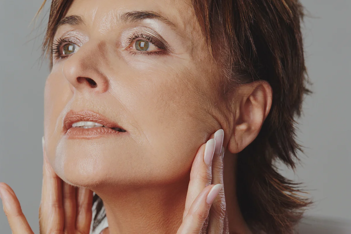 Senior woman touching jaw line with fingers