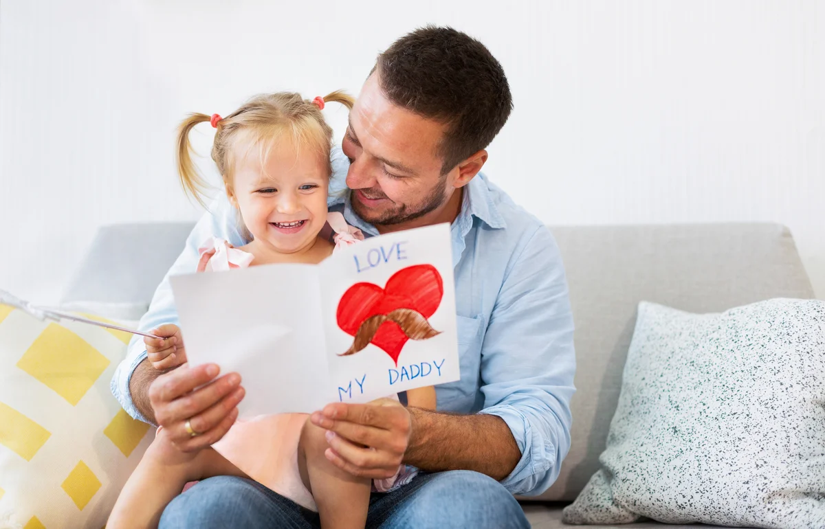 Father and toddler with card