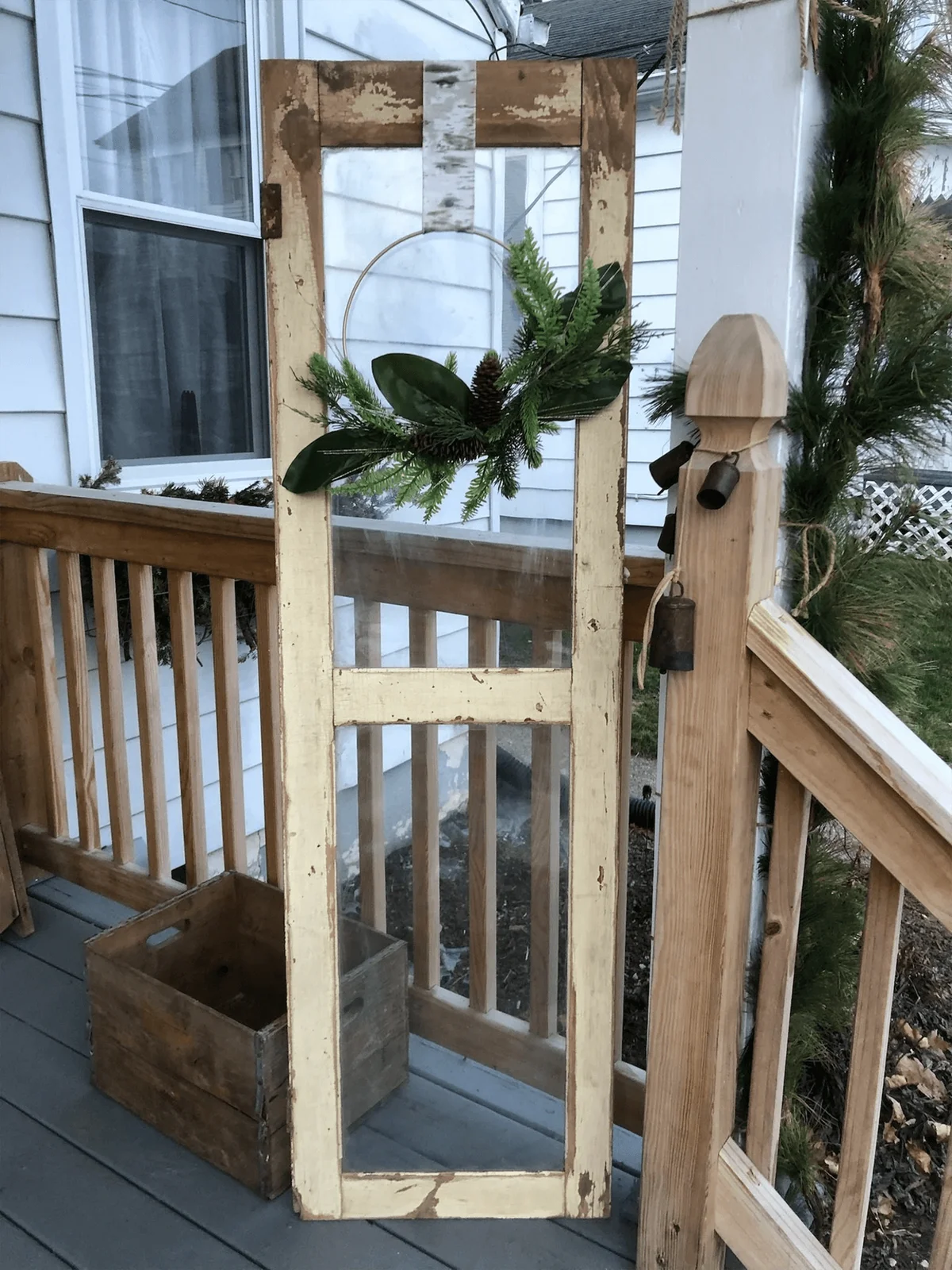 Greenery wreath hanging from antique glass door