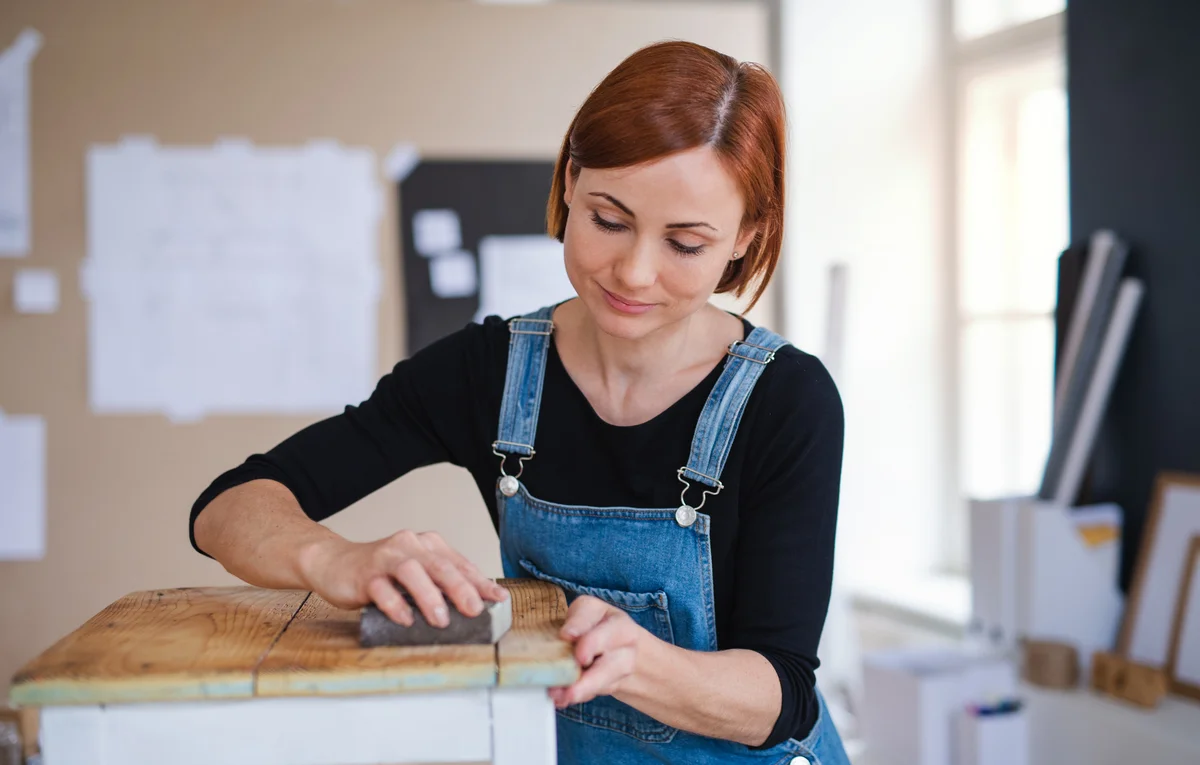 Woman sanding rustic table