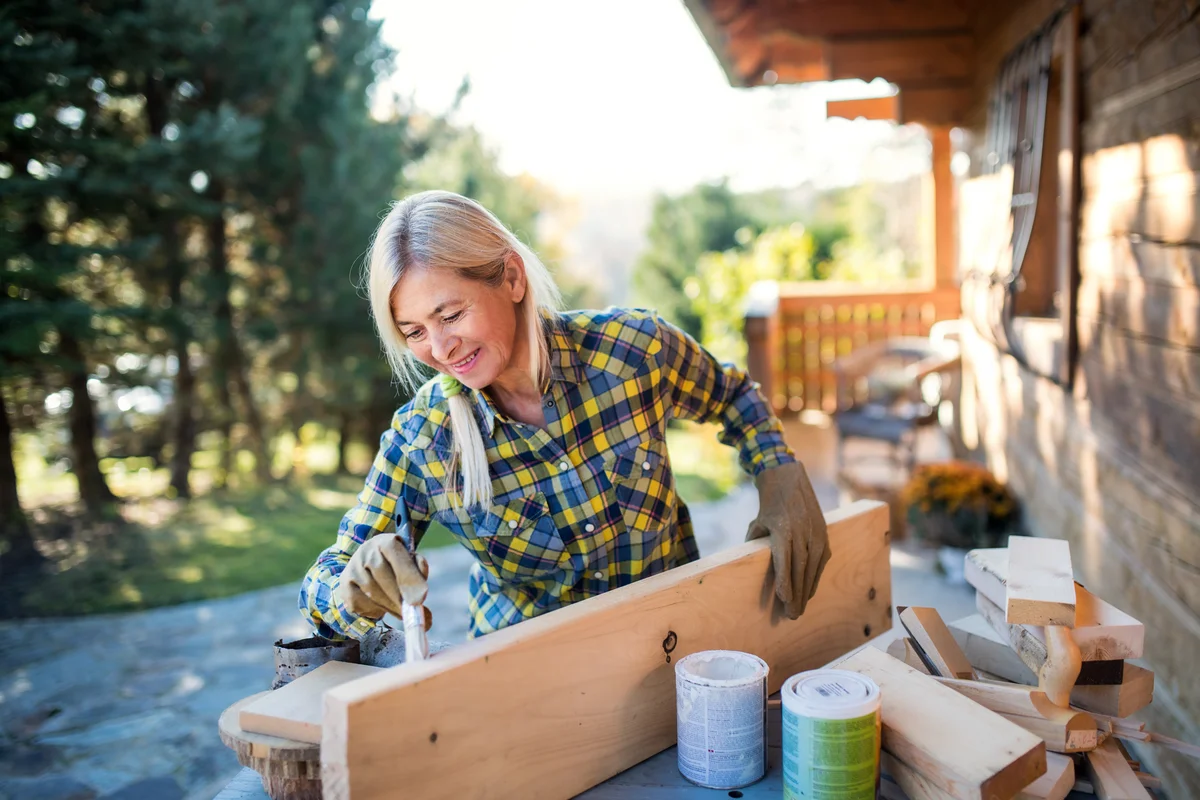 Senior woman building a wooden shelf