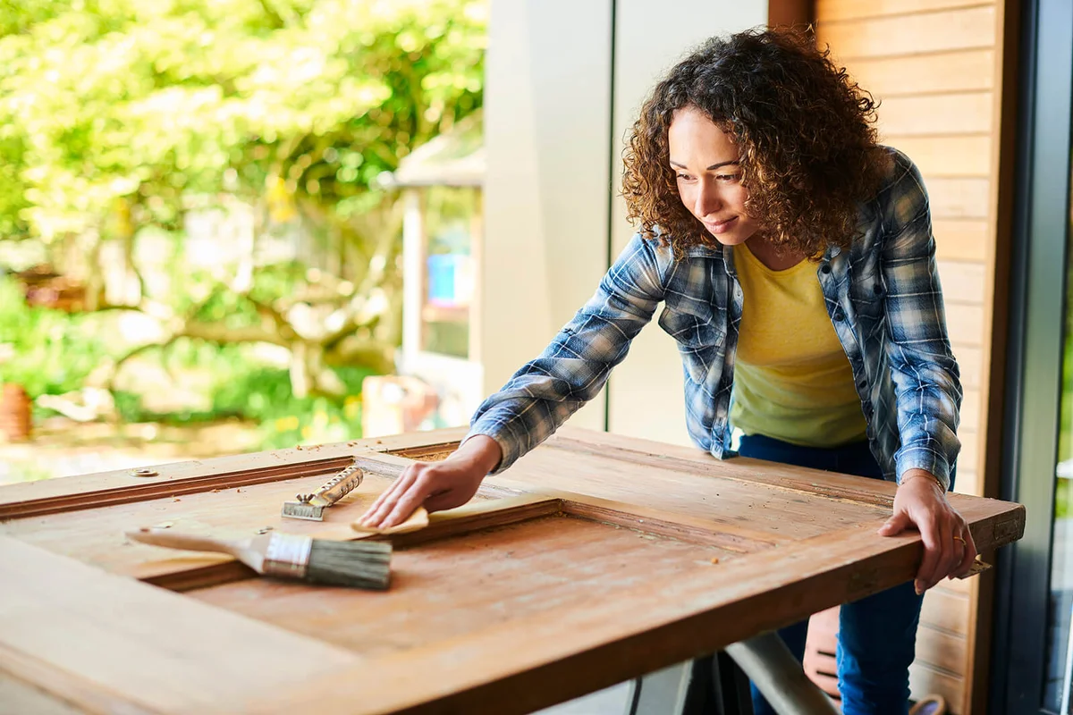 woman working on restoring antique door