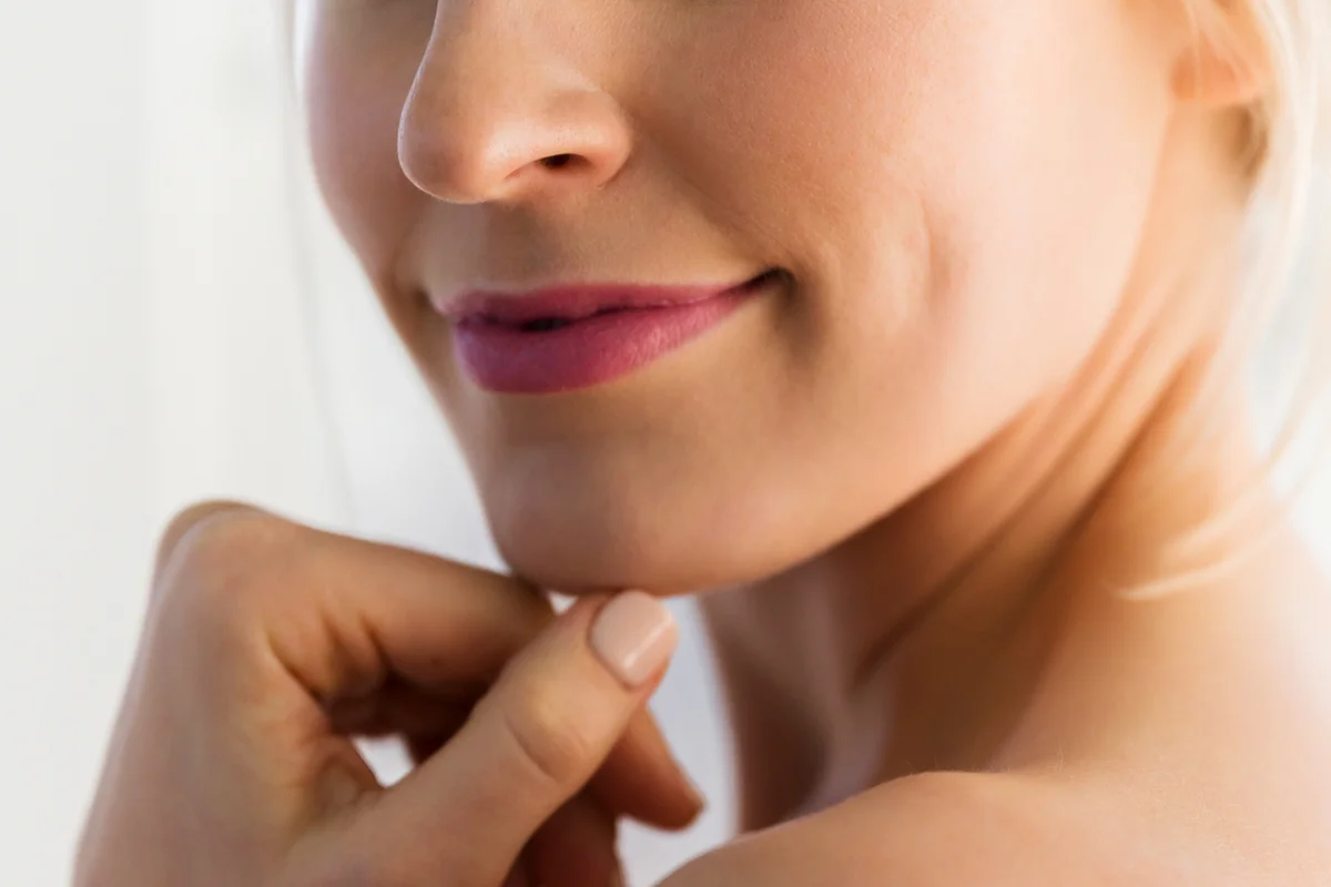 Close up of woman's smile and bare shoulder