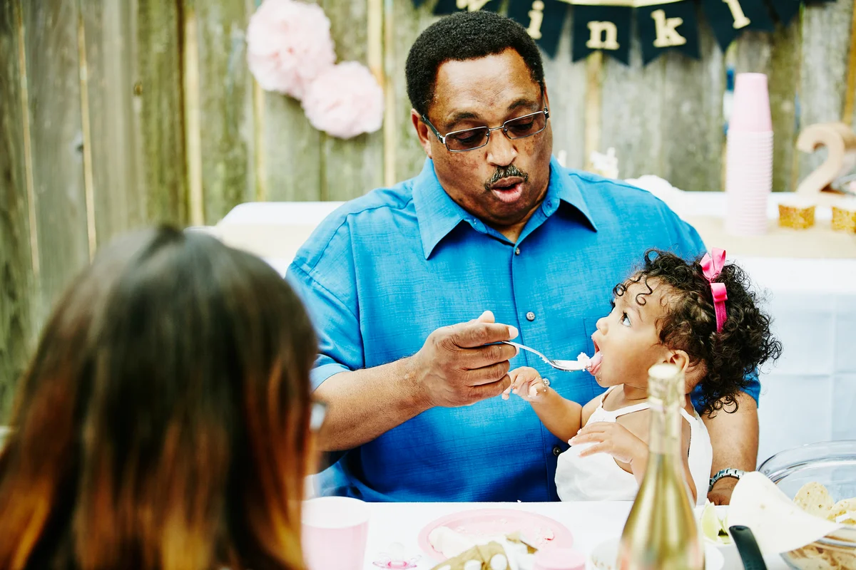 grandfather feeding a baby cake