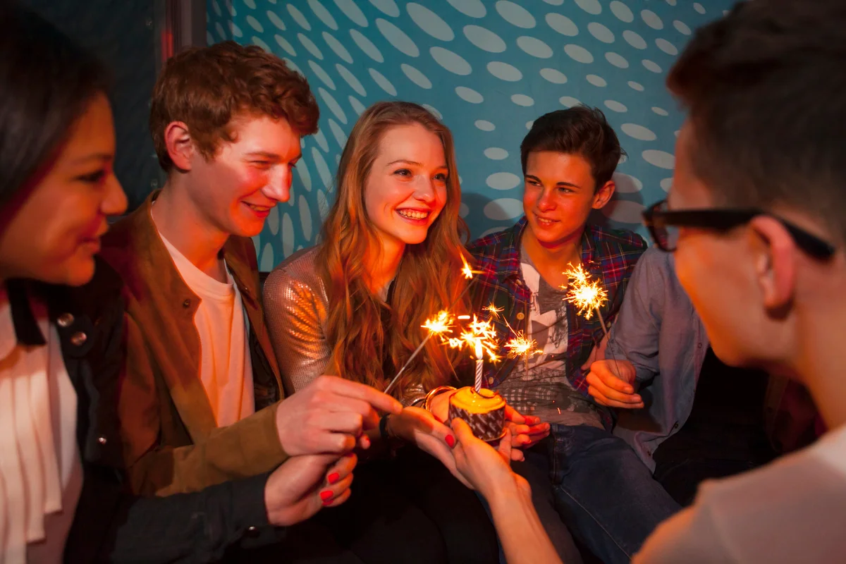 group of teens with birthday sparklers