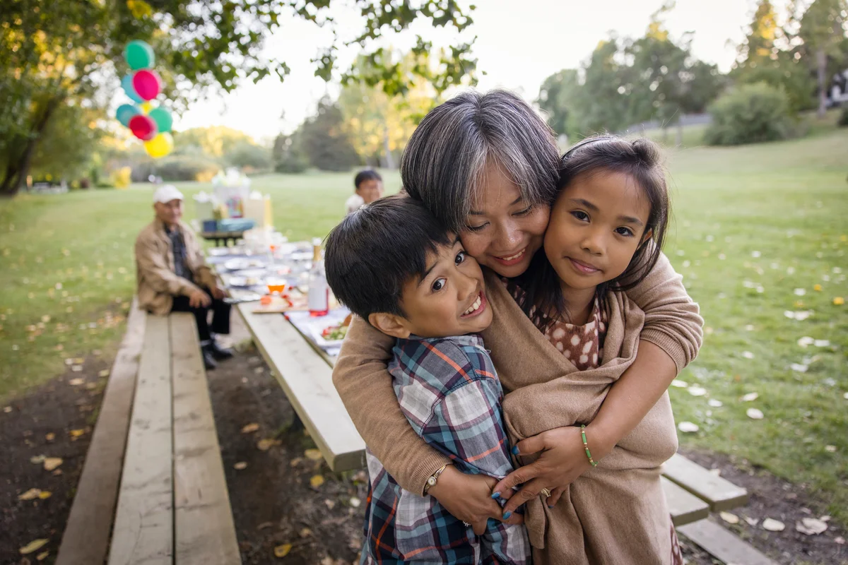 adult hugging two children