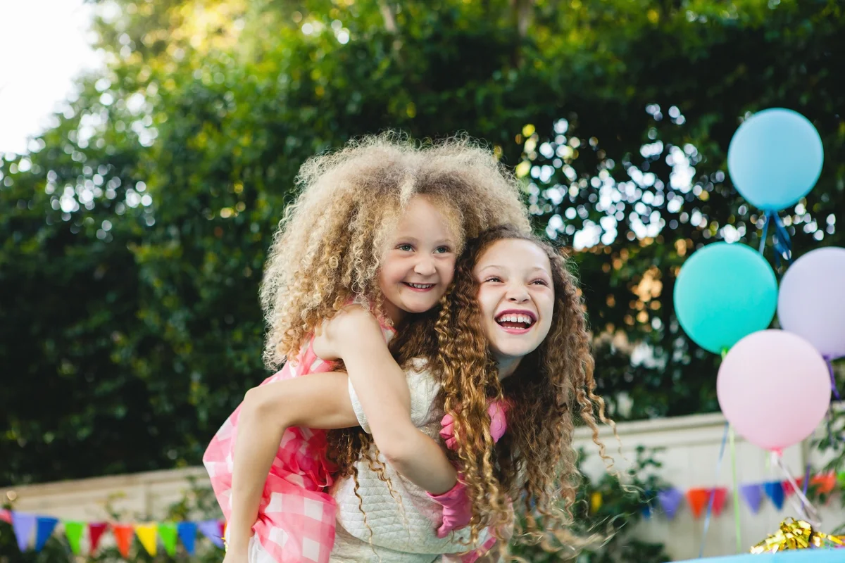 older sister giving her younger sister a piggyback