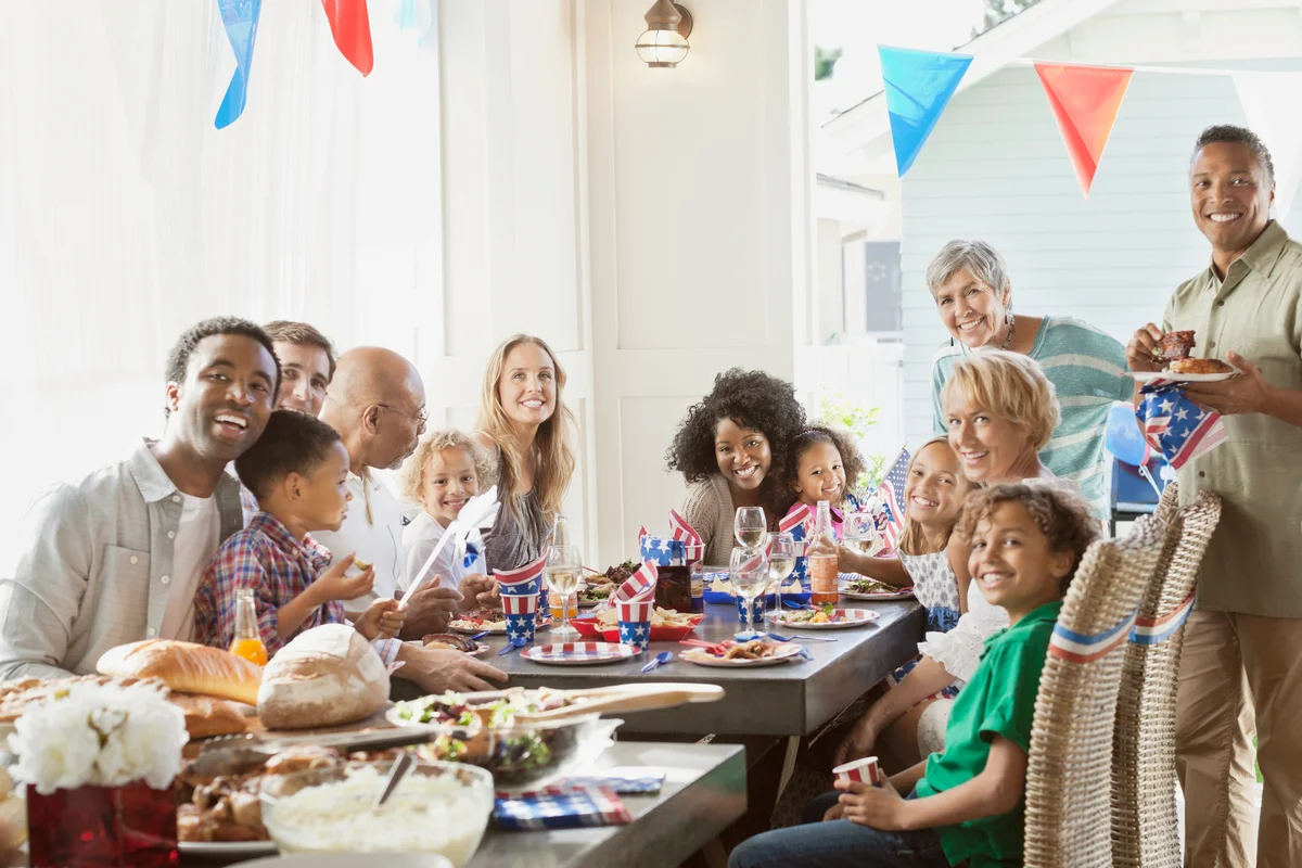 Family and friends at dining table celebrating the 4th of July