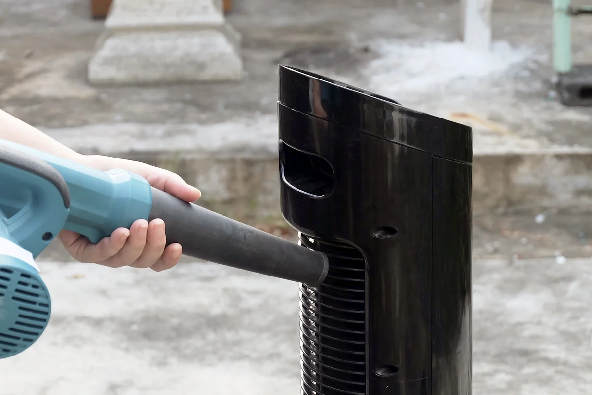 Person Use Blower Cleaning A Tower Fan