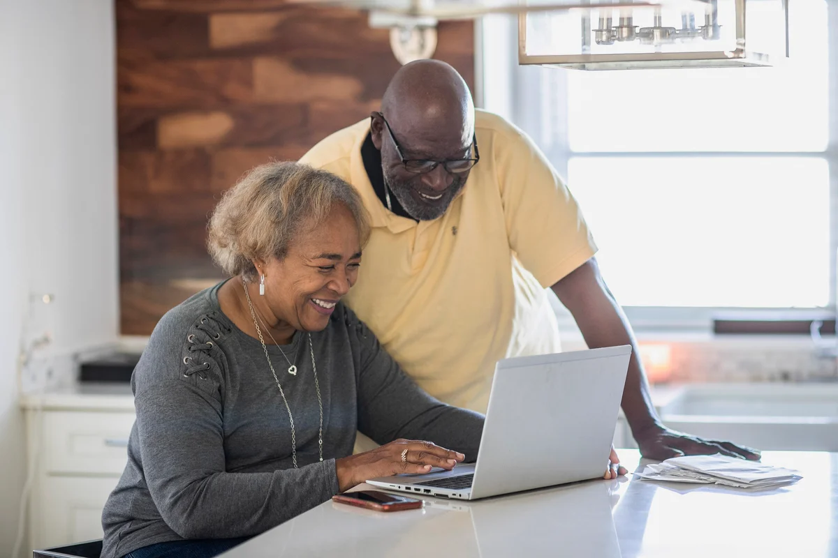 Senior couple using laptop in the kitchen