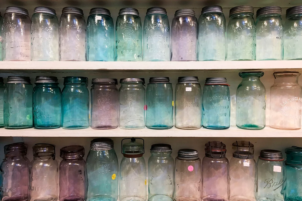 Antique glass canning jars on a shelf