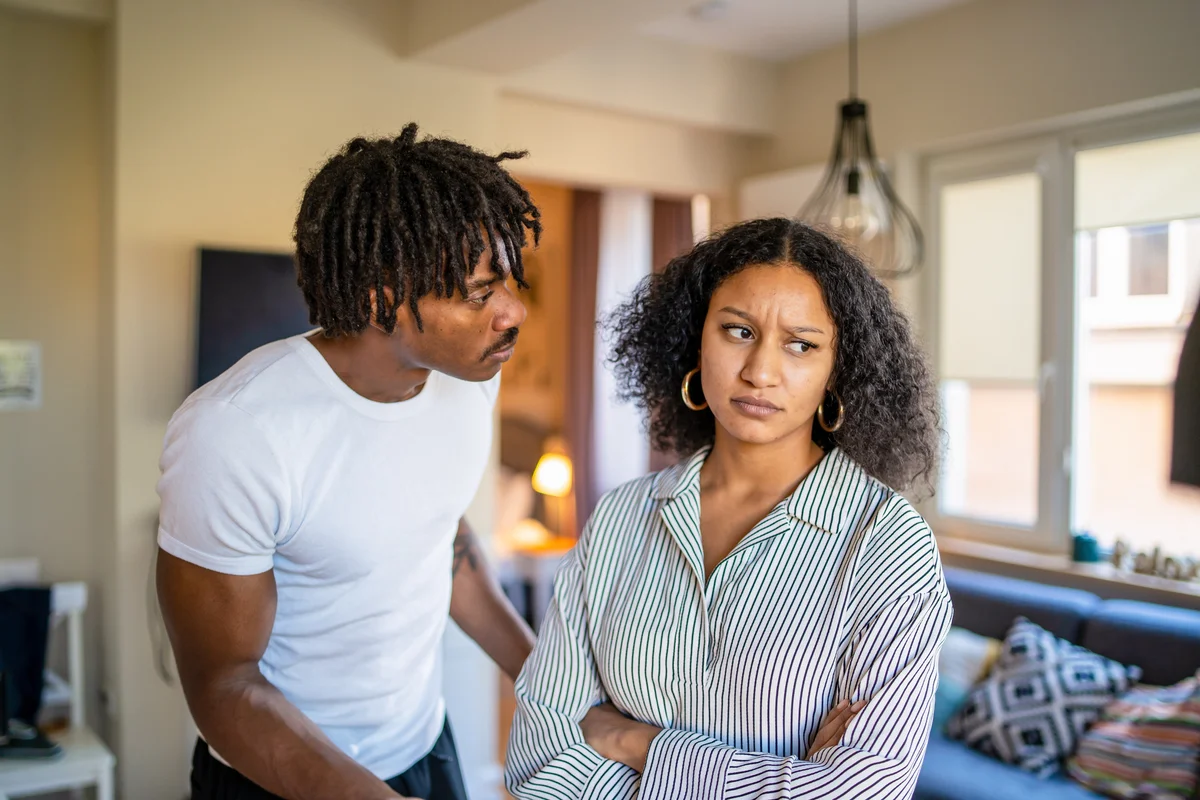 Woman looking angry next to man talking at her