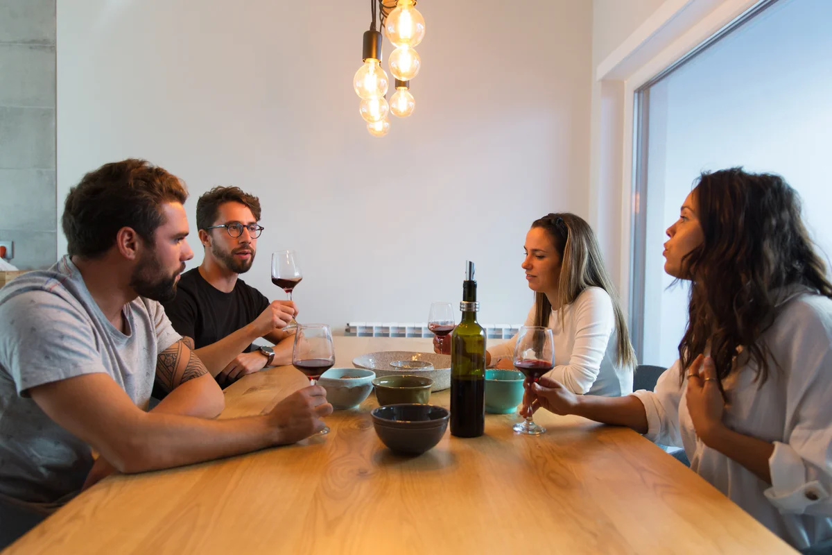 Couples sitting at table drinking wine and arguing