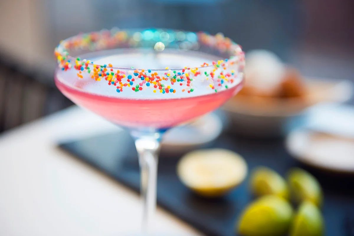 Colorful cocktail decorated with hundreds and thousands on the rim