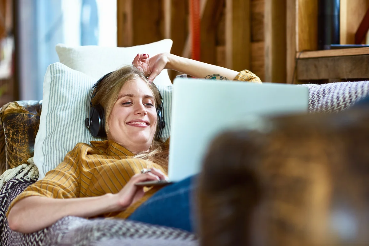 Woman using laptop to watch series with headphones
