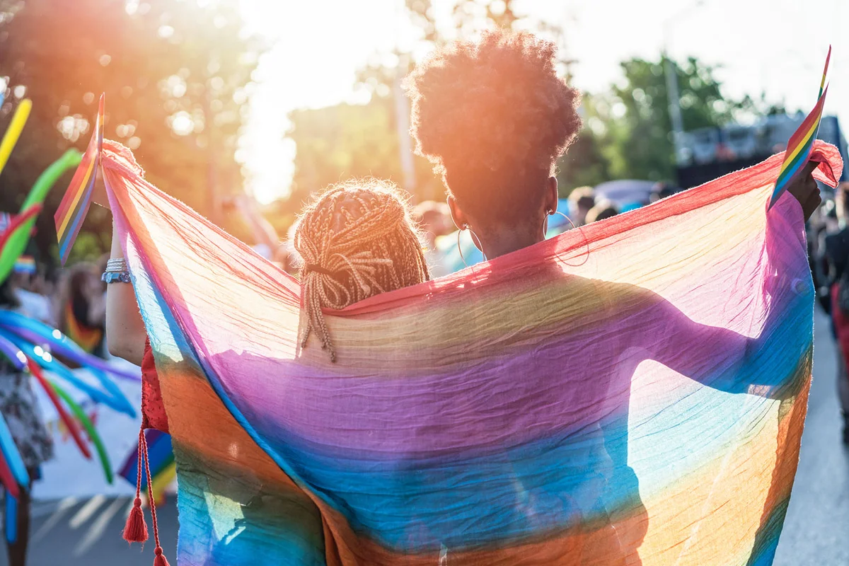 Young female couple walking the streets with the pride parade