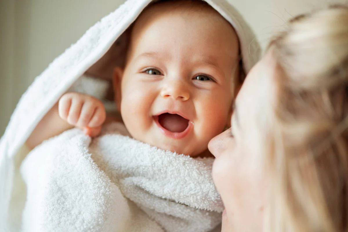Woman carrying her baby girl at home
