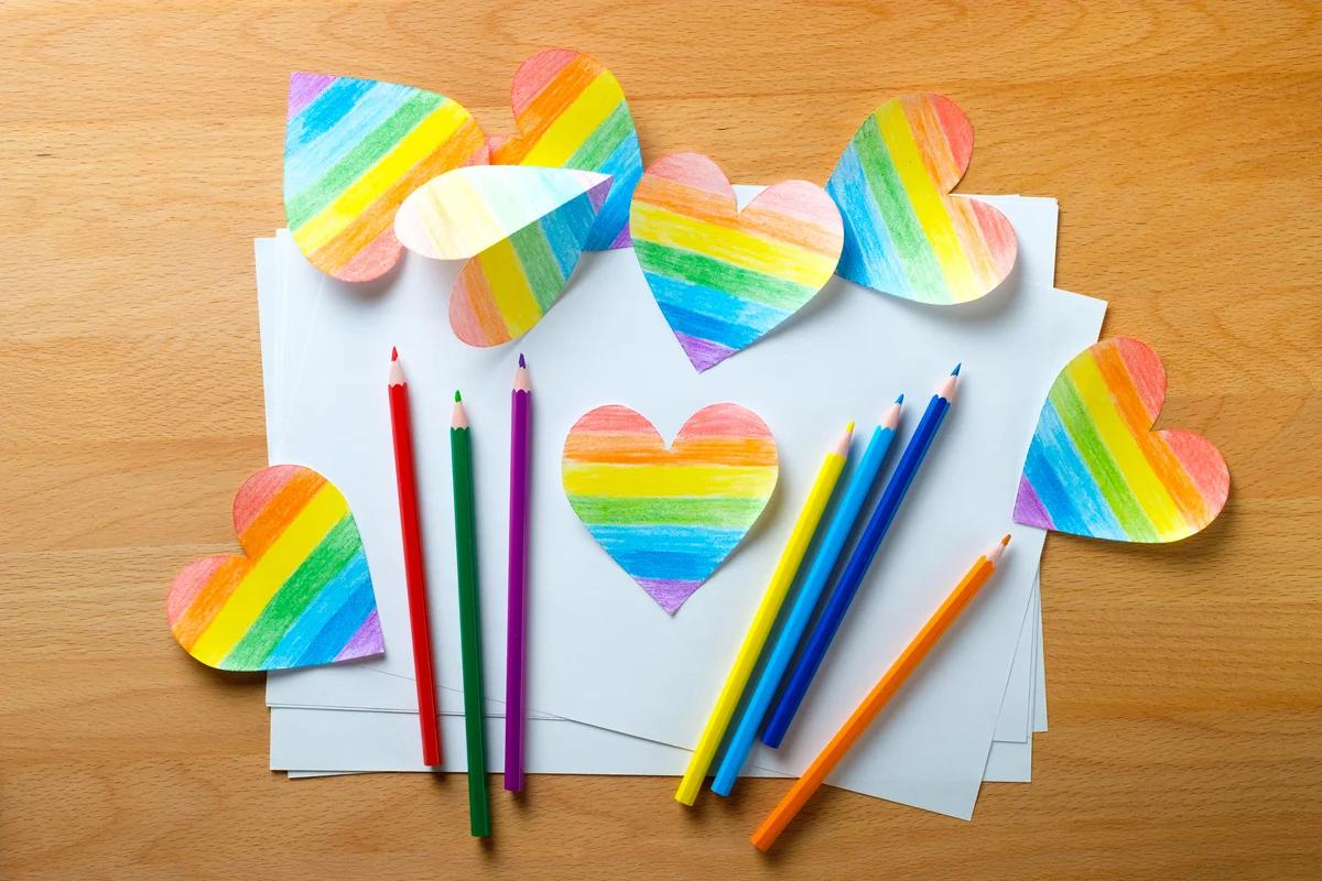 rainbow hearts, paper, and pencils