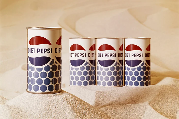 Vintage Pepsi drink tins on sand