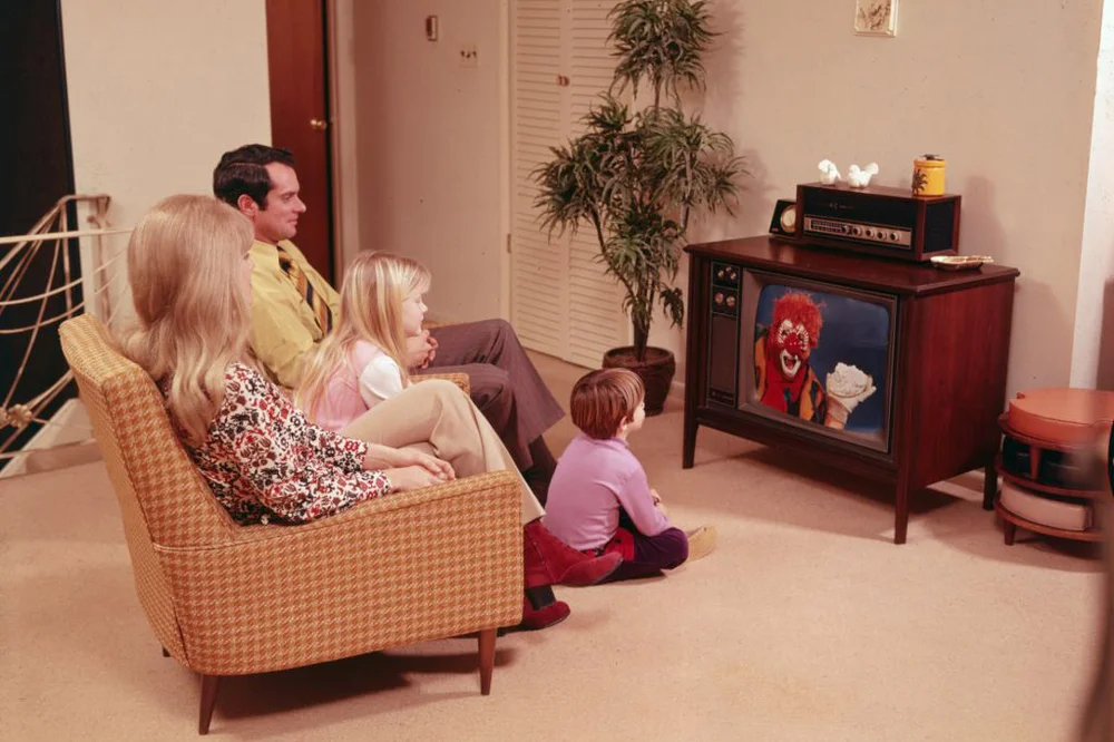 1970s Family sits in their living room watching television