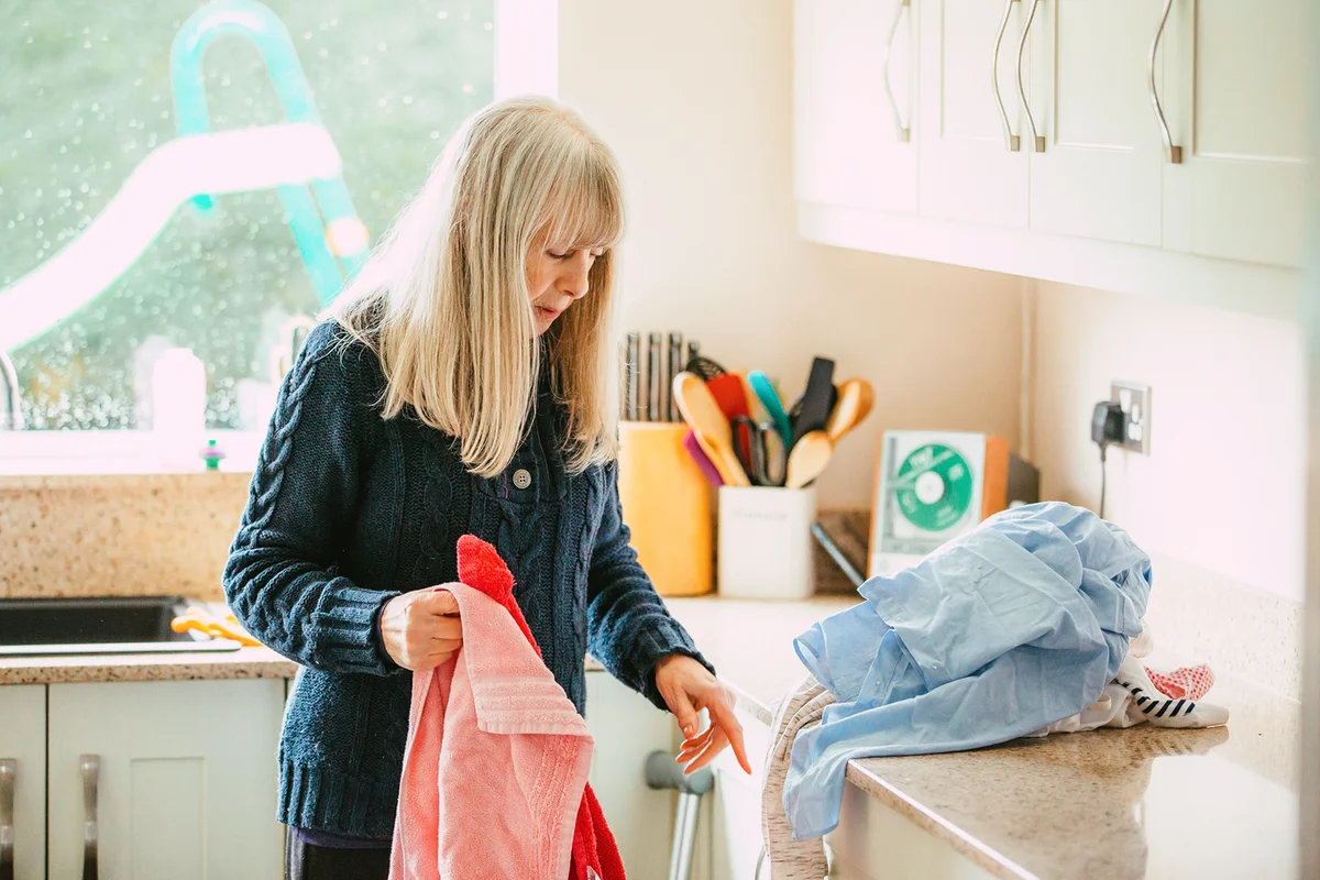 Senior woman sorting the laundry in her kitchen