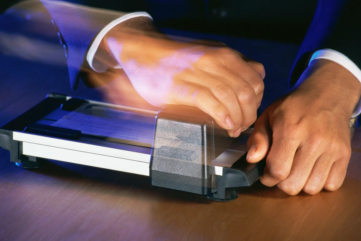 Hands operating credit card sales slip imprinter