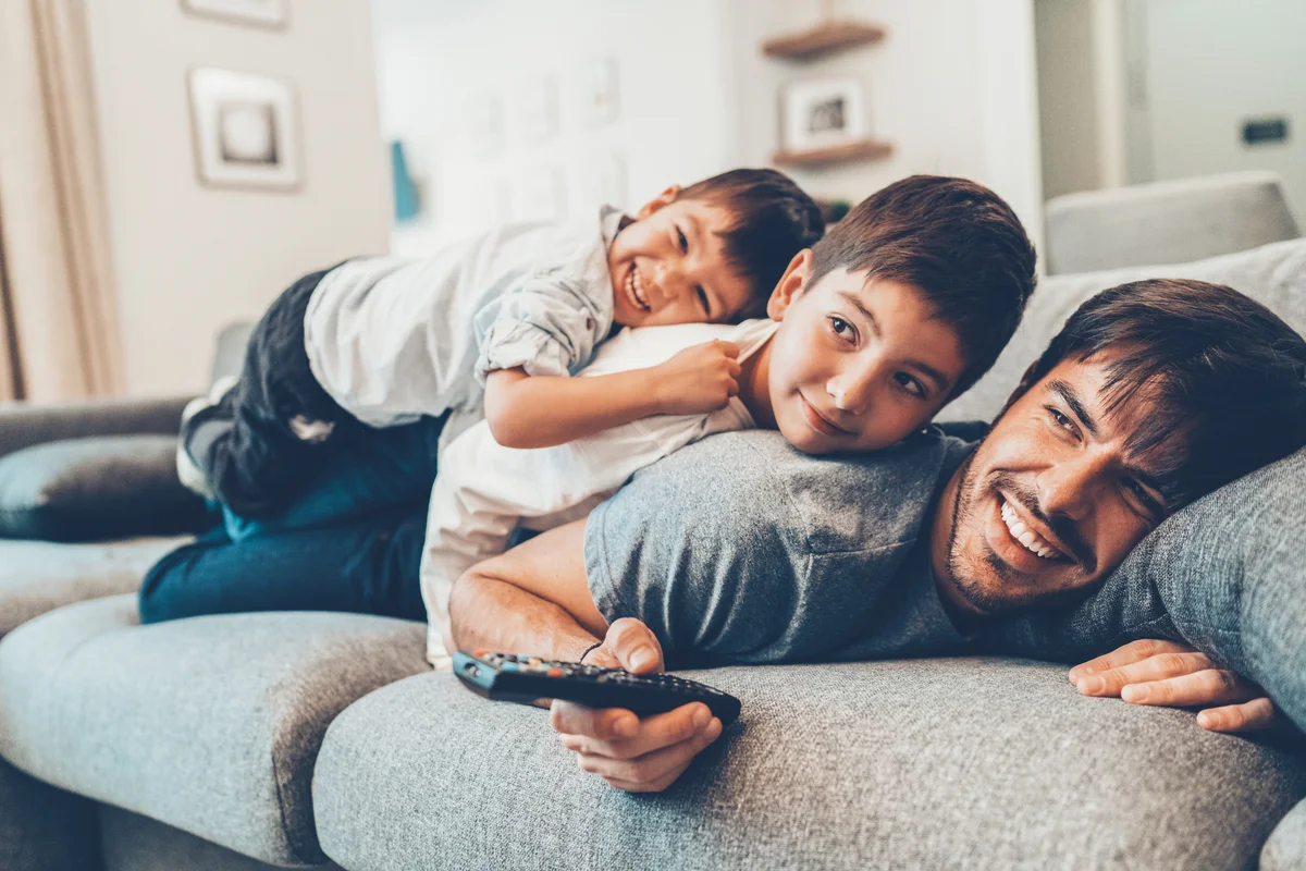 father and sons watching tv