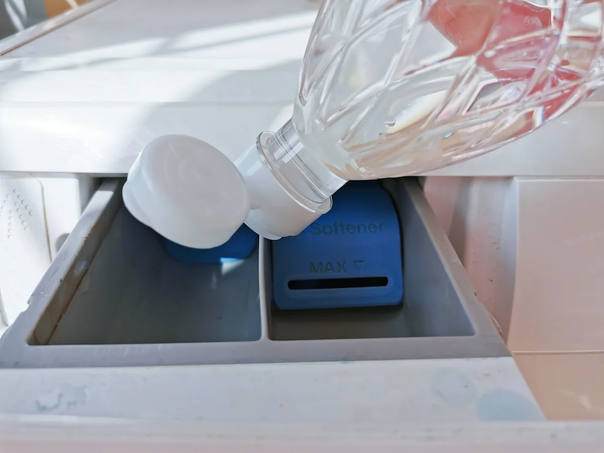 pouring vinegar in laundry