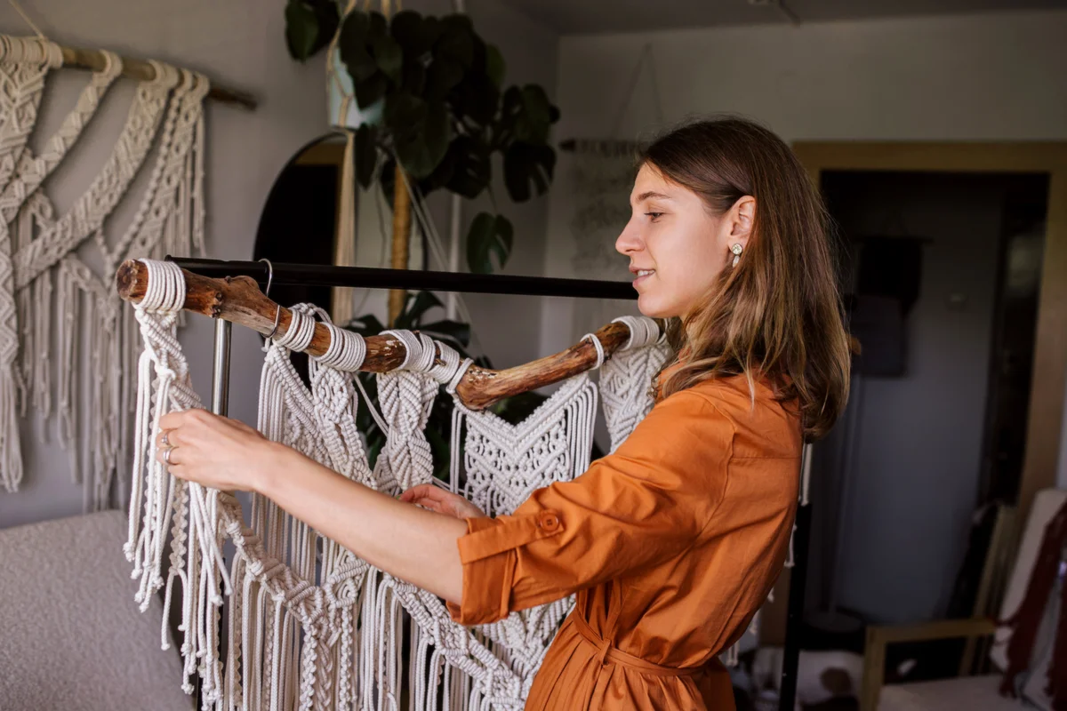 woman holding a macrame wall hanging